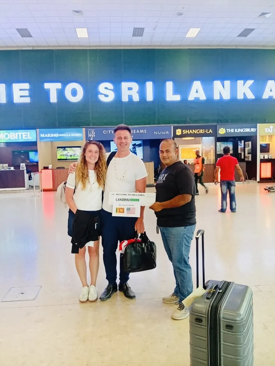 Private driver greeting international tourists upon arrival at Sri Lanka airport.