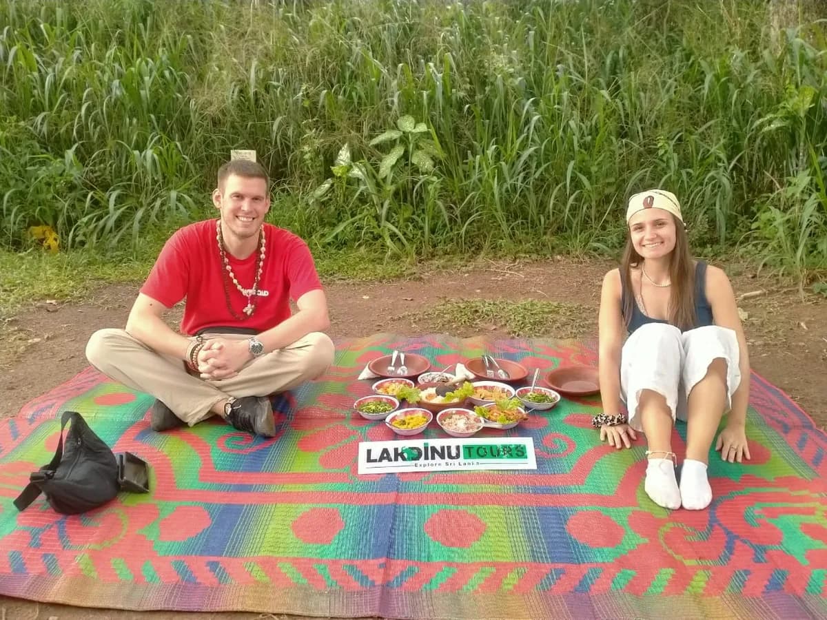 Tourists enjoying an outdoor picnic surrounded by scenic nature in Sri Lanka.